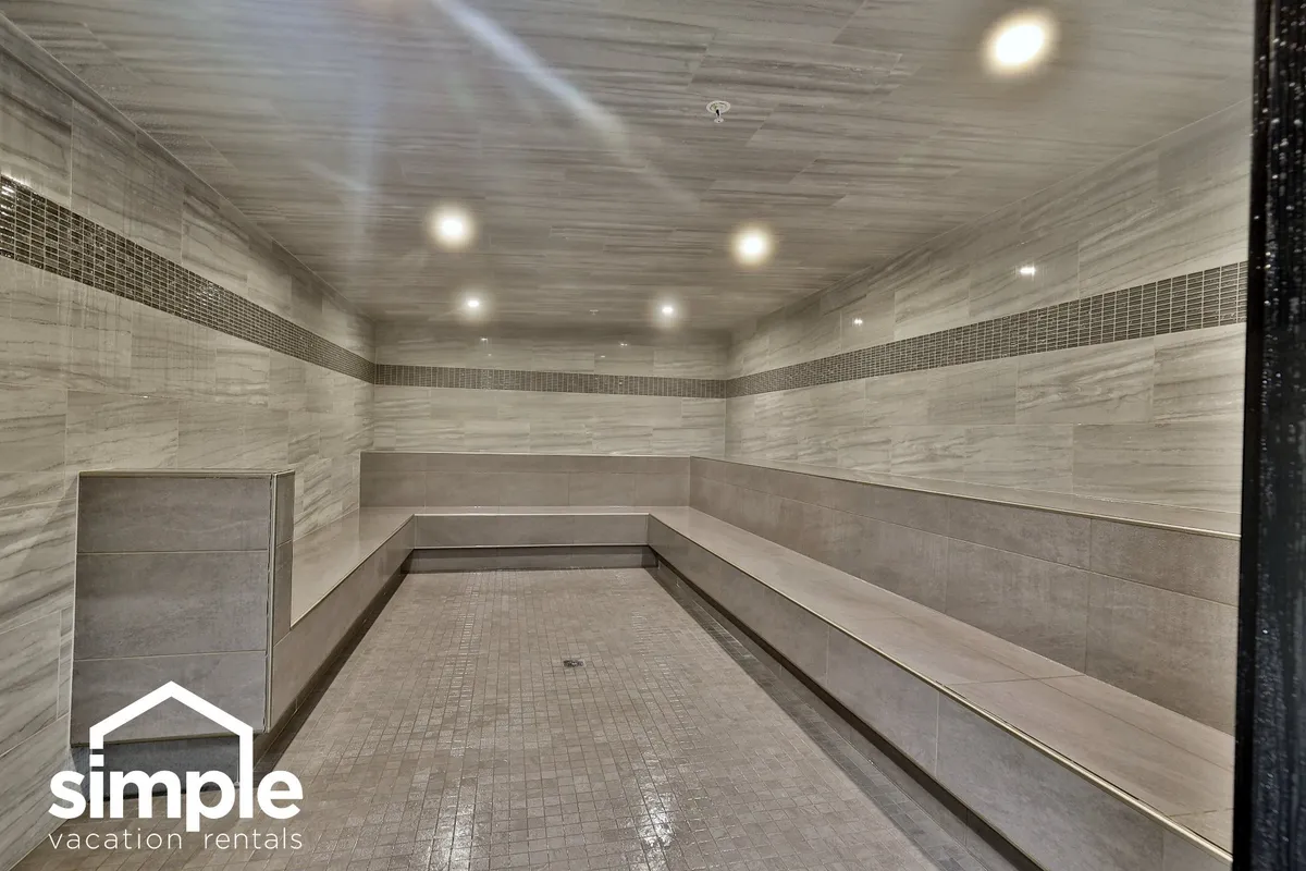 A tranquil communal lounge area with spacious seating, smooth tiled surfaces, and soft lighting. The scene evokes relaxation and comfort, suggesting a welcoming shared amenity where guests might unwind after a day outdoors.